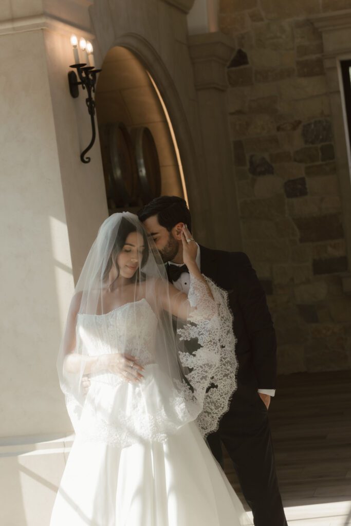 Bride leaning on groom with sweeping veil at Monserate Winery