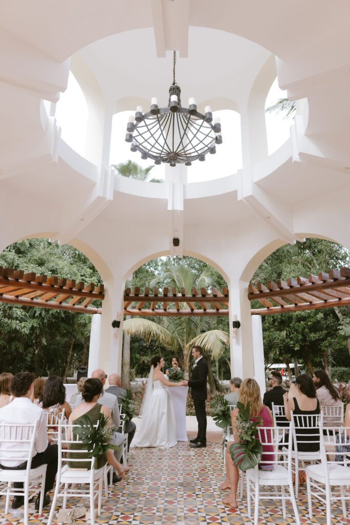 Bride and groom exchanging vows at a Playa del Carmen resort wedding.