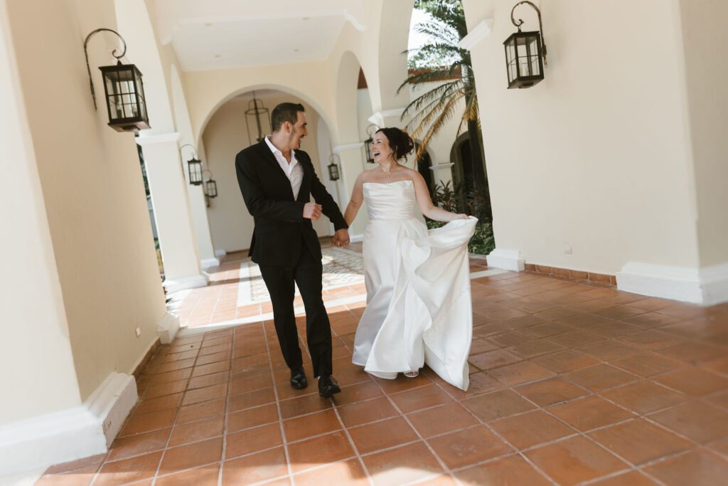 Bride and groom walking through the arched corridors at Valentin Imperial Riviera Maya.