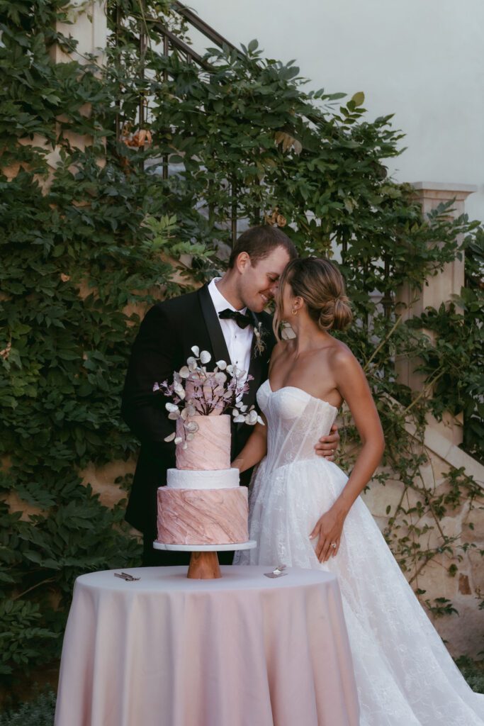 Bride and groom cutting a luxury wedding cake during their reception at Monserate Winery.